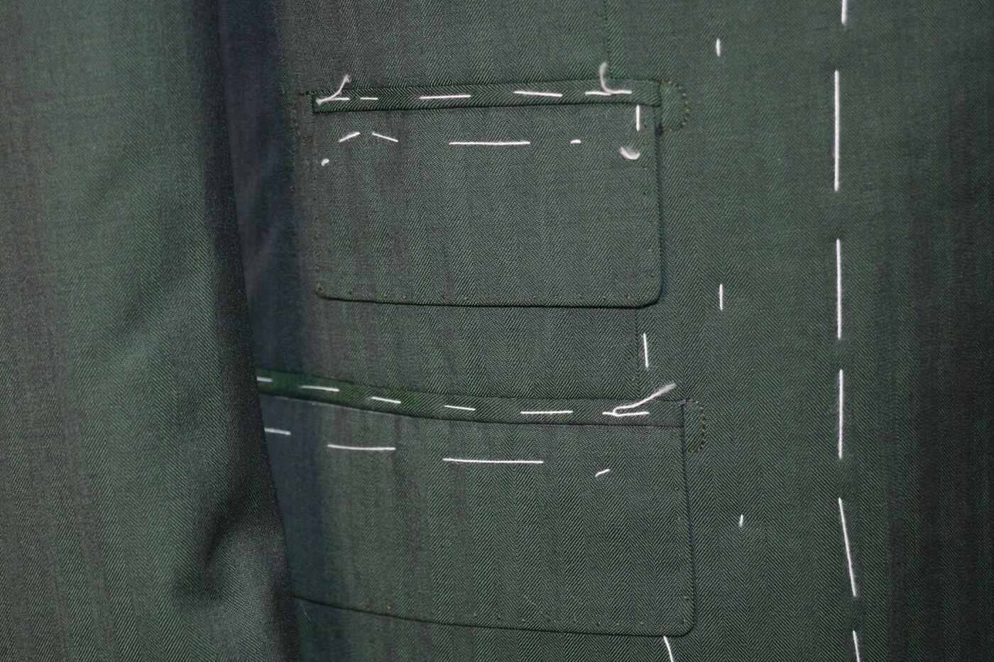 Dettaglio delle tasche di una giacca imbastita durante la lavorazione sartoriale